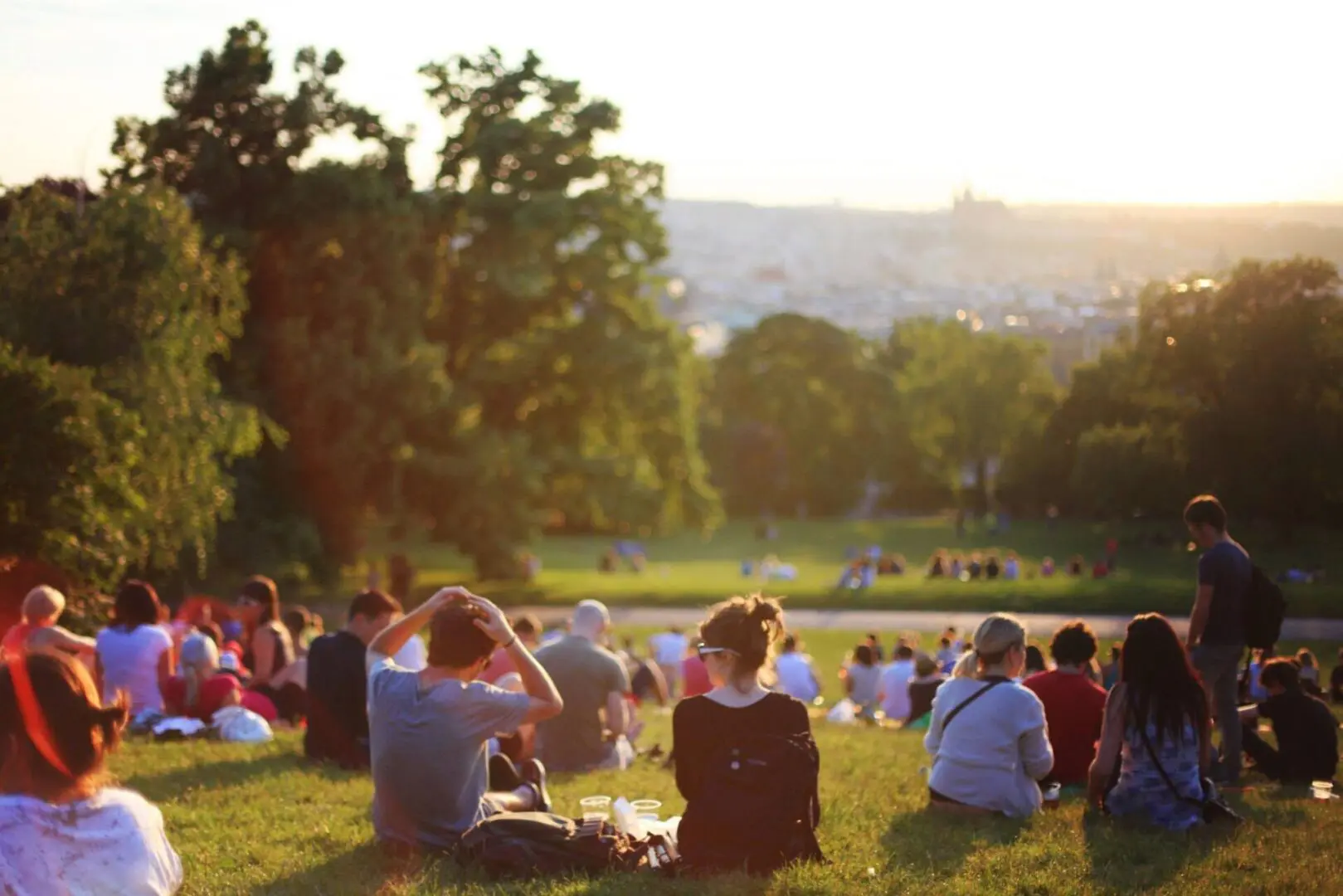 A group of people sitting in the grass.